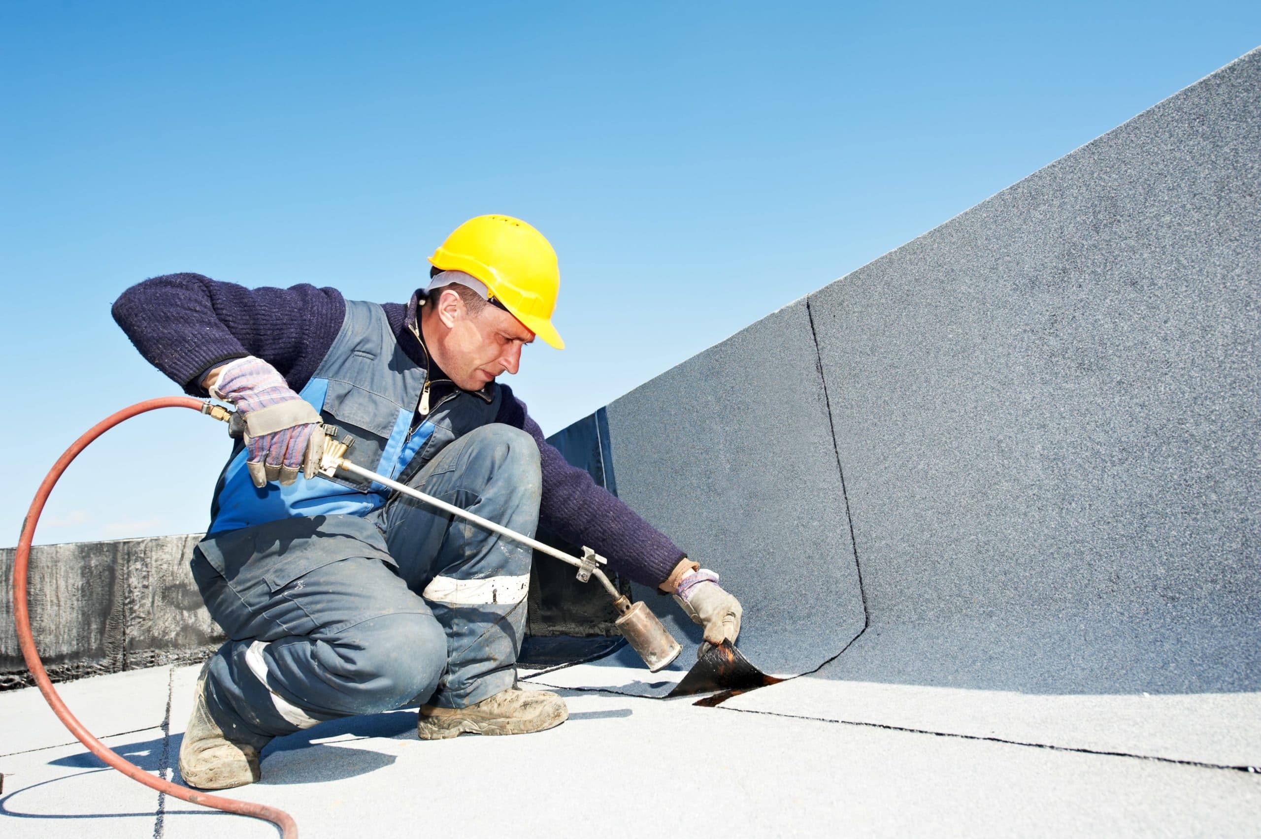 Roofer Working on a Flat Roof - Roofing Companies - Get Your Quote