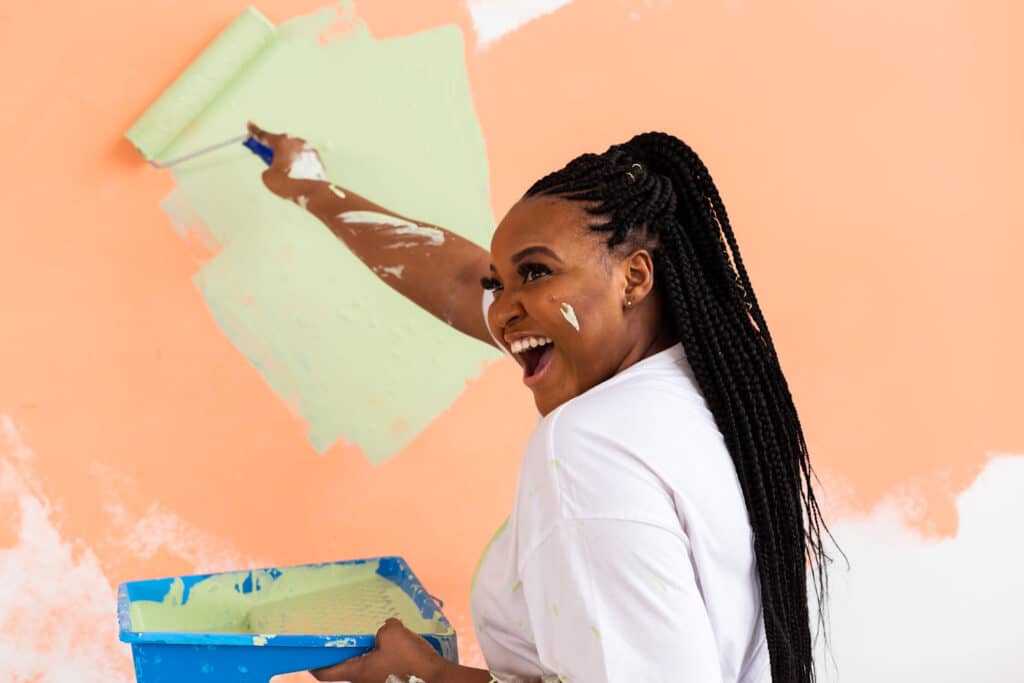 woman painting with a laugh and smile